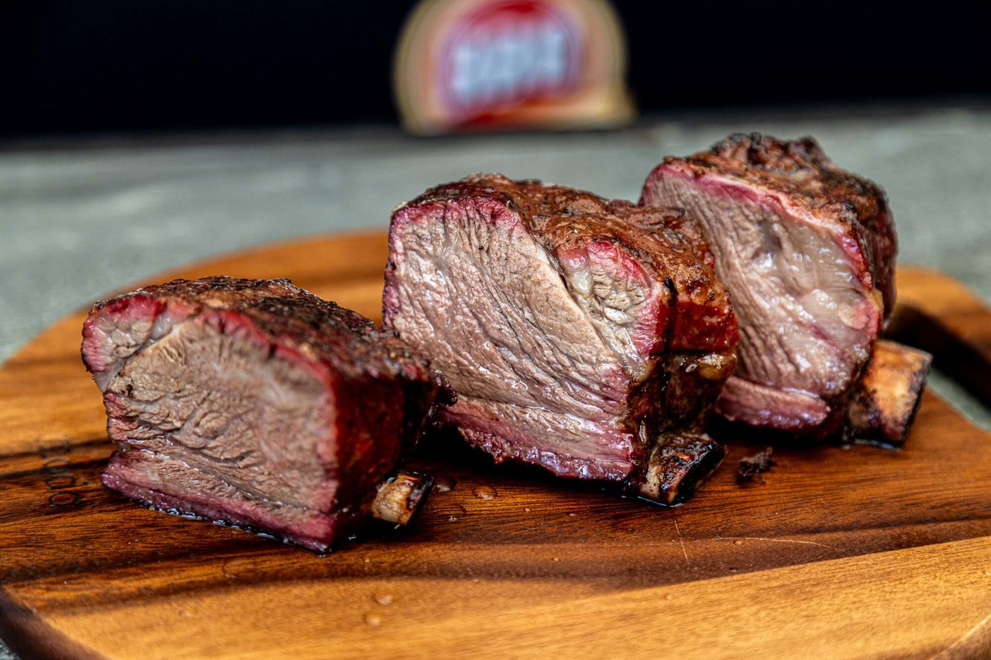 Murray Pure Beef Ribs cooked and sliced, showcasing rich color and tenderness on a wooden cutting board.